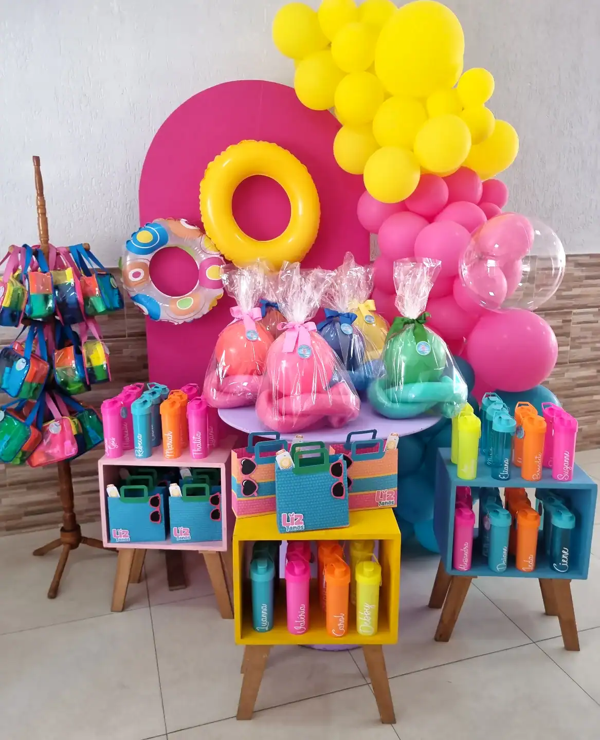 Pool Party Favor Table with Colorful Water Bottles and Floaties