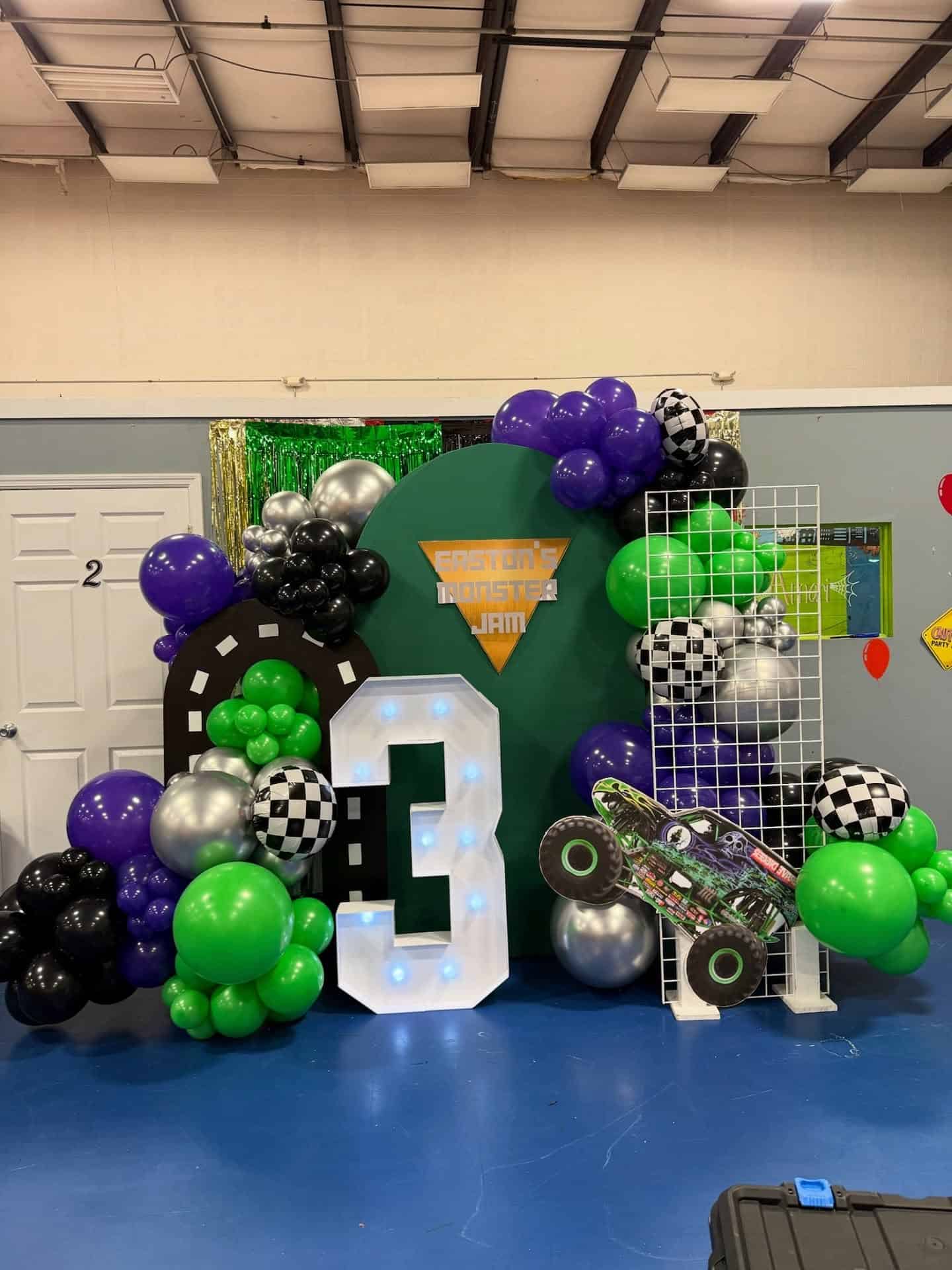 Monster Truck Party Setup with Light Up Number and Balloon Garland