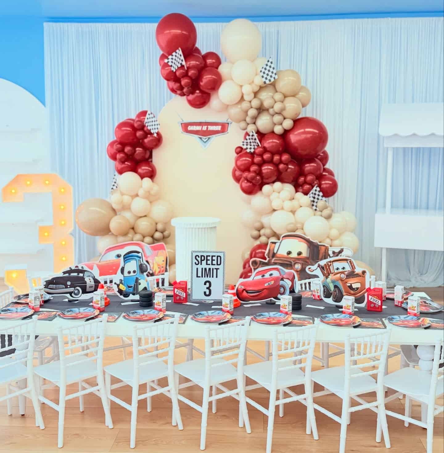 Cars Birthday Party Setup with Balloon Garland and Character Cutouts