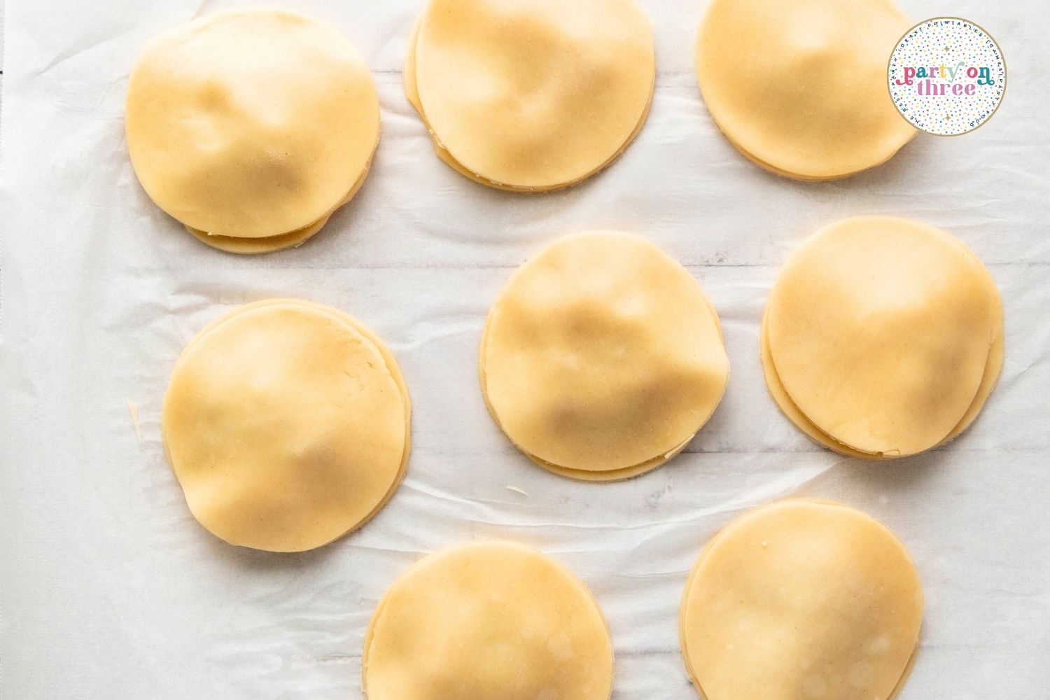 Unbaked hand pies with top dough circles placed over filling before crimping the edges
