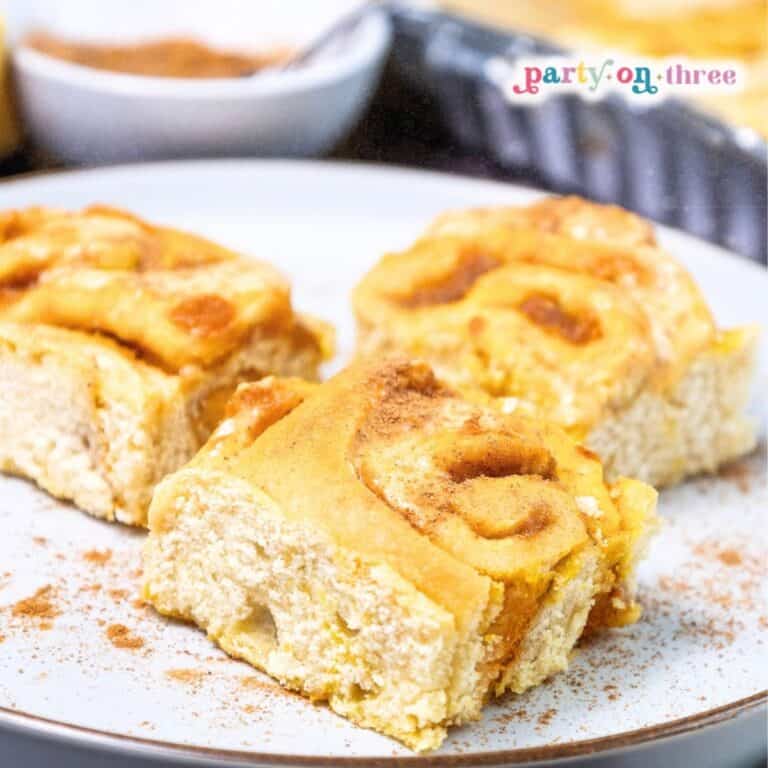Pumpkin cinnamon rolls on a plate labeled as the ultimate fall breakfast treat