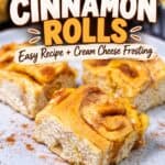 Homemade pumpkin cinnamon rolls with cream cheese frosting banner on a plate