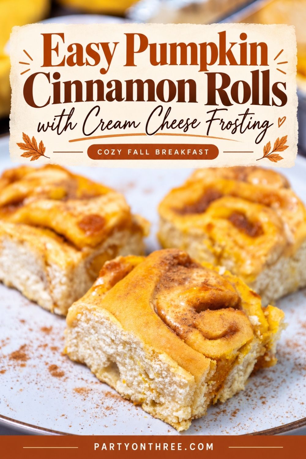 Frosted pumpkin cinnamon rolls on a plate with cream cheese frosting text overlay