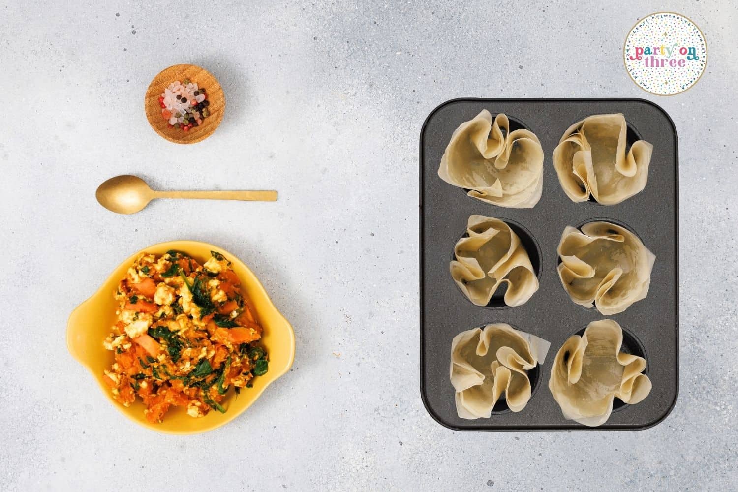 Phyllo shells in a muffin tin next to the filling.