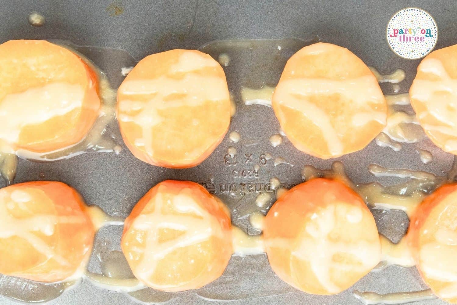 Sweet potato rounds coated in melted butter and salt arranged in a baking pan