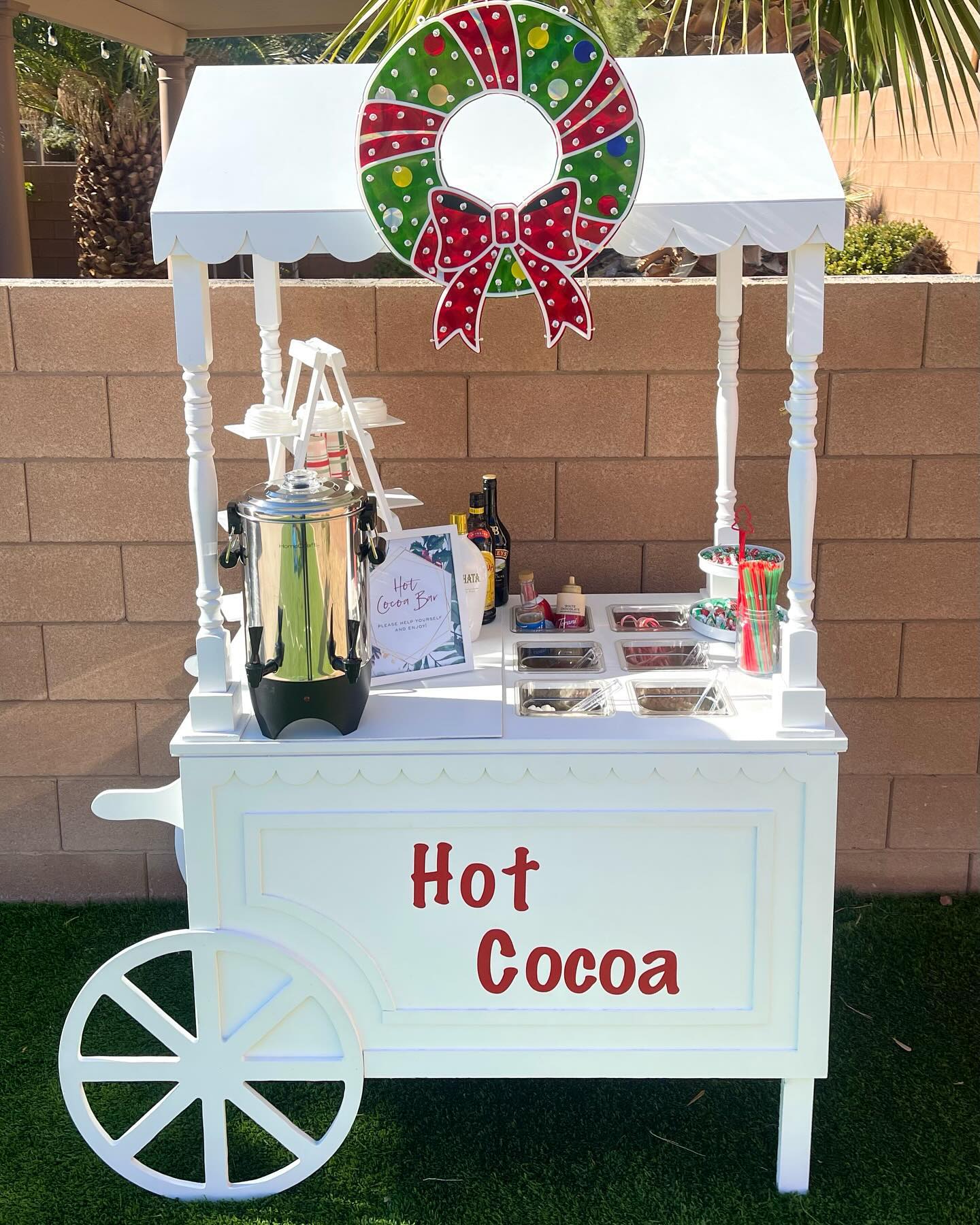 A Wheeled Cocoa Cart With a Lit Wreath on Top