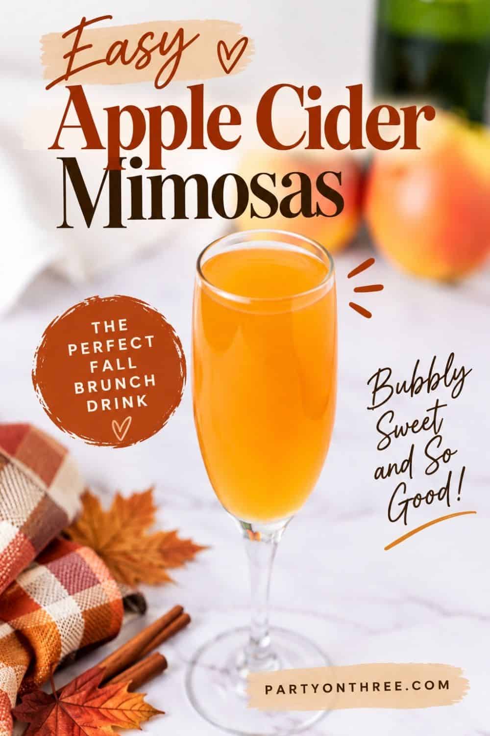 Glass of Apple Cider Mimosa with cinnamon sticks, fall leaves, and apples on a marble counter.