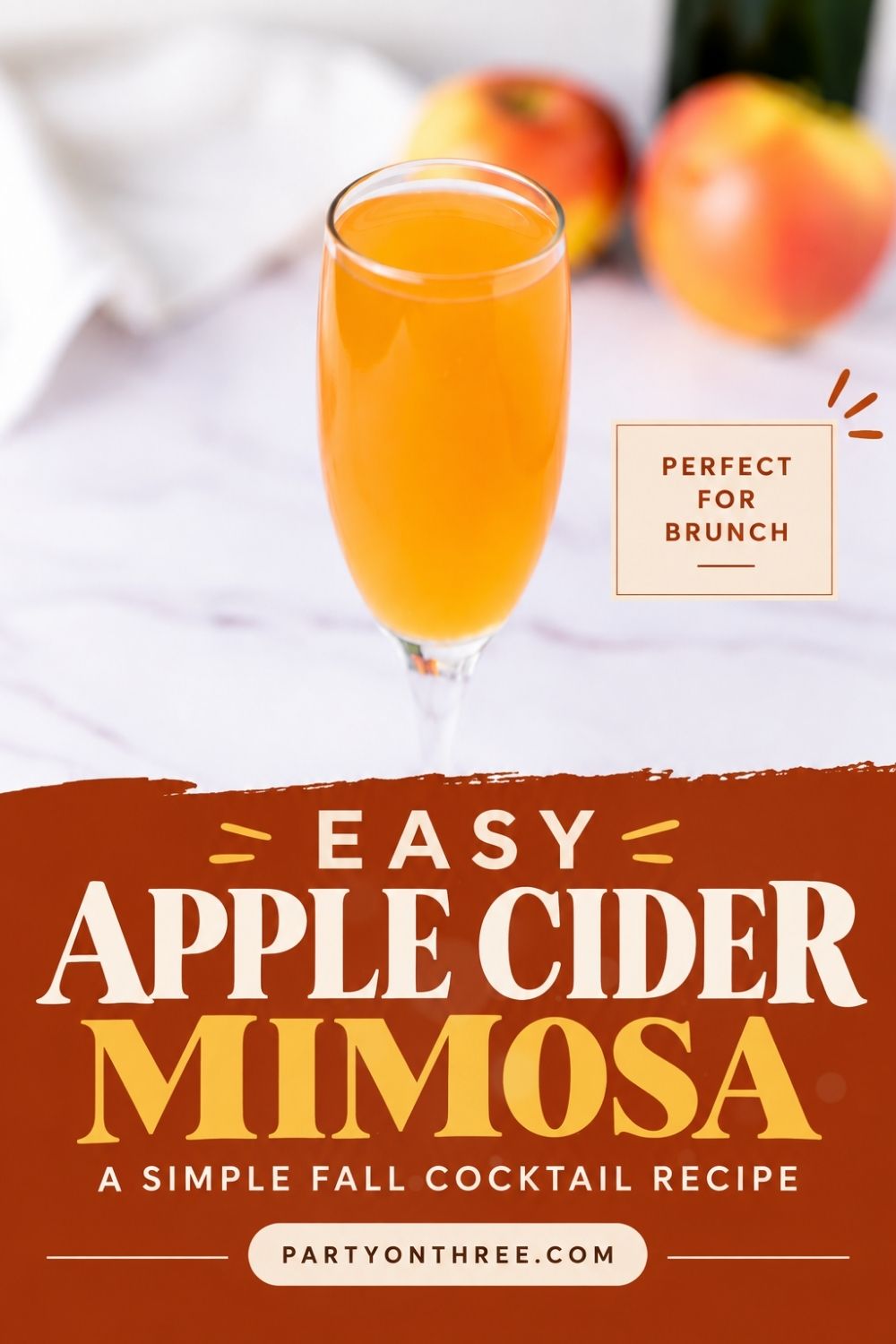 Apple Cider Mimosa in a champagne flute with apples blurred in the background