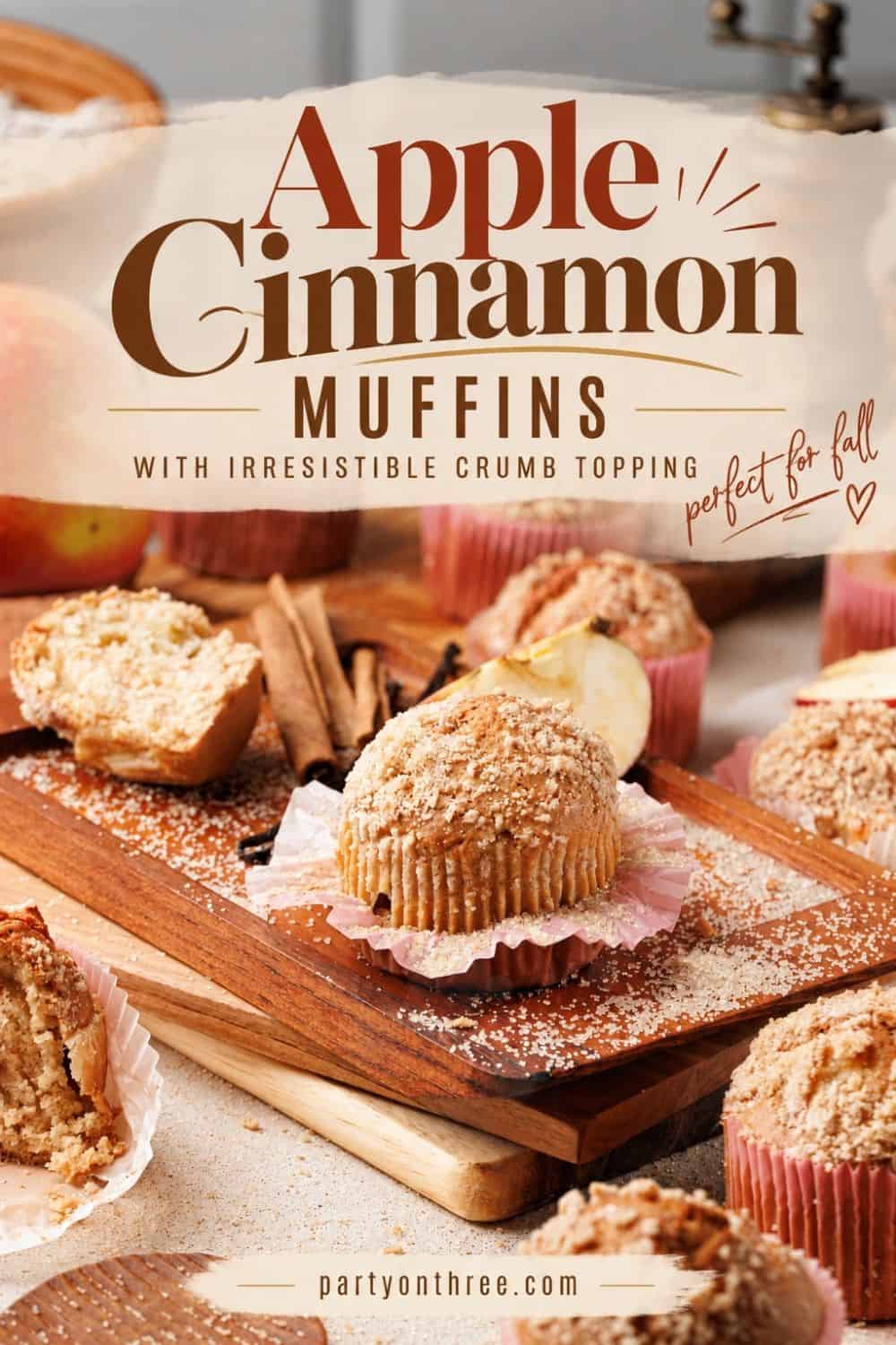 Apple cinnamon muffins with crumb topping on a wood board, surrounded by cinnamon sticks and apple slices