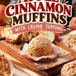 Apple cinnamon muffins with crumb topping on a wooden board, surrounded by cinnamon sticks and fresh apple slices.