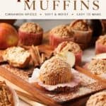 Apple cinnamon muffins with crumble topping on a wood board, surrounded by cinnamon sticks and apple slices