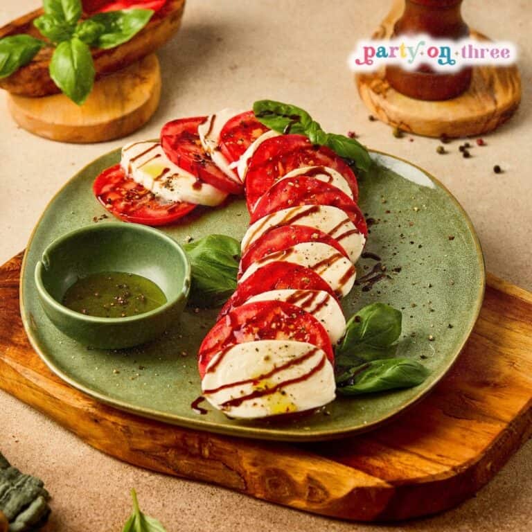 Caprese Candy Cane appetizer arranged on a green plate with balsamic glaze, basil, and oil dip