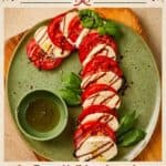 Caprese Candy Cane salad arranged on a green plate with balsamic glaze, basil, and dipping oil