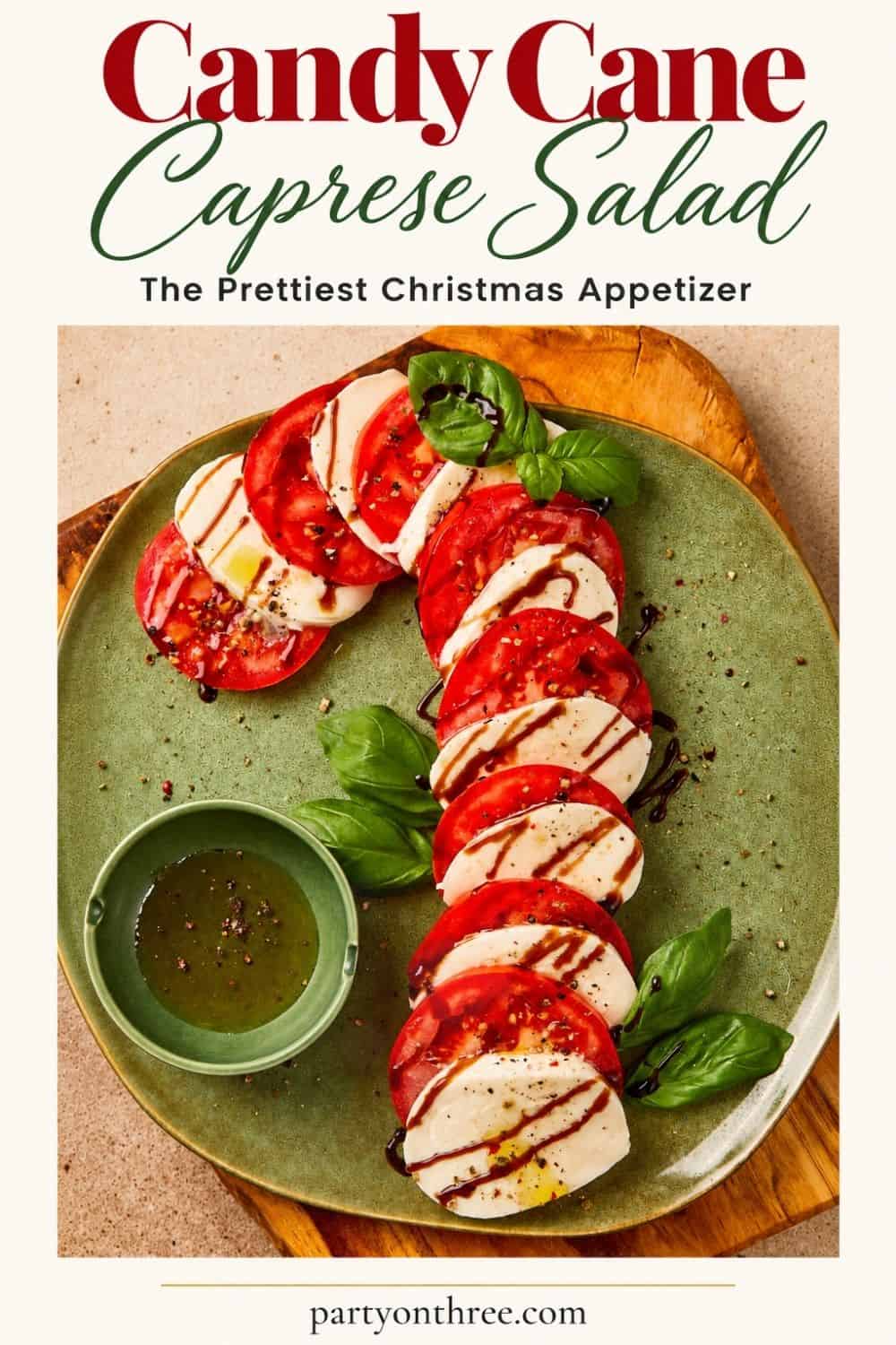 Caprese Candy Cane appetizer on a green plate, tomato and mozzarella slices with balsamic glaze and basil