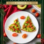 Christmas appetizer of pita triangles topped with mashed avocado and diced tomatoes, shaped like trees