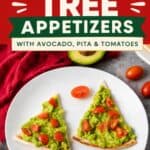 Christmas appetizer triangles of pita topped with mashed avocado and diced tomatoes shaped like trees