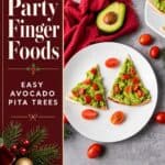 Christmas appetizer plate of avocado pita tree triangles topped with cherry tomatoes, beside a halved avocado