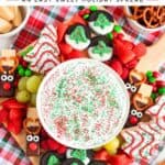 Christmas charcuterie board with marshmallow fruit dip, pretzel reindeer, chocolate-dipped Oreos, fruit, and candy