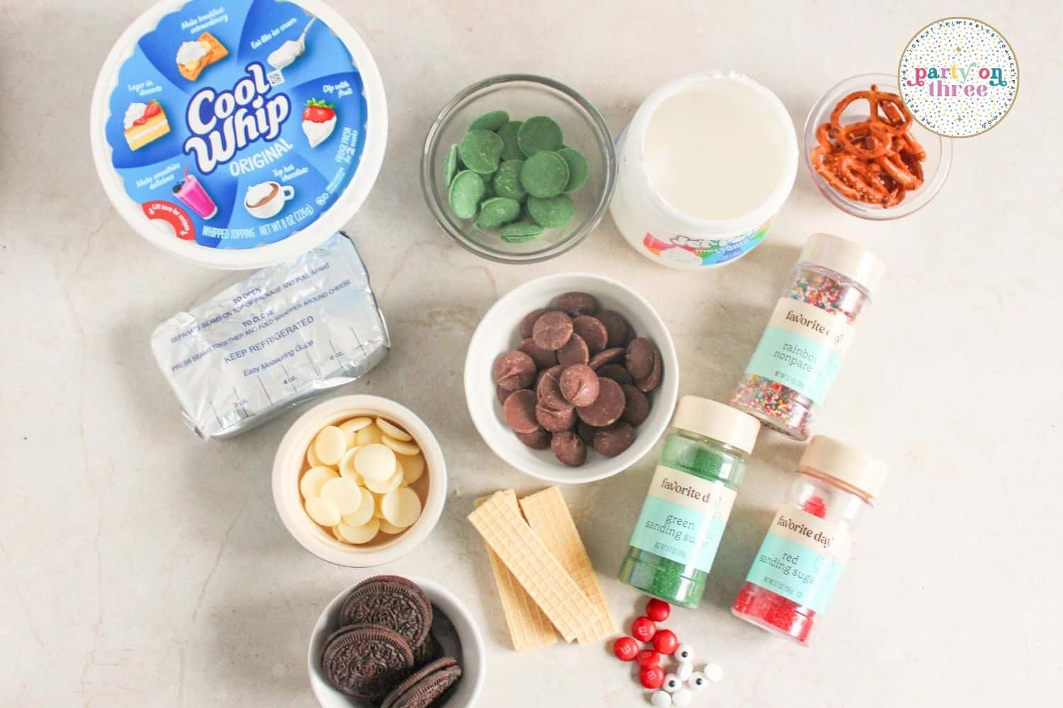 Ingredients for Christmas charcuterie board: Cool Whip, cream cheese, candy melts, Oreos, pretzels, sprinkles, and M&Ms.