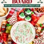 Christmas charcuterie board with marshmallow fruit dip, reindeer pretzels, cookies, and fresh fruit