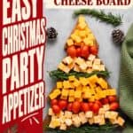 Christmas cheese board shaped like a tree with cheddar cubes, cherry tomatoes, and rosemary sprigs