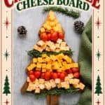 Christmas cheese board arranged in a tree shape with cheddar cubes, cherry tomatoes, and rosemary sprigs