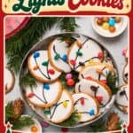 Christmas Light Cookies decorated with icing and candy buttons on a tin tray with pine branches