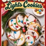 Christmas Light Cookies with white icing and candy lights arranged on a tin, surrounded by pine sprigs.