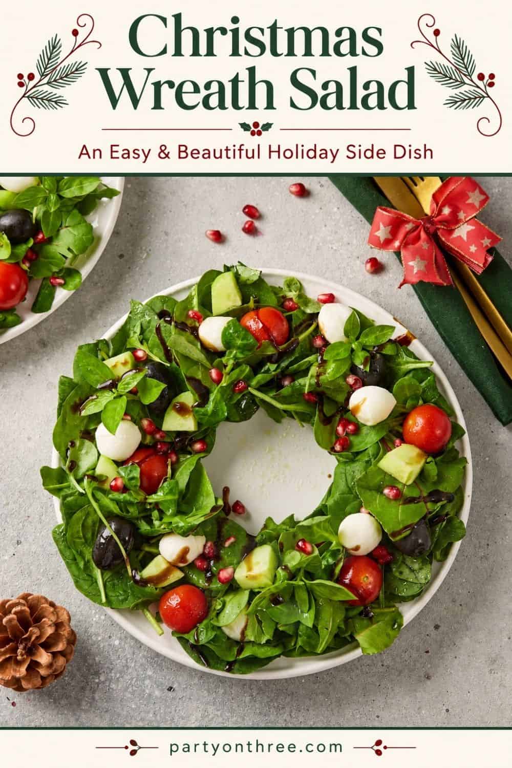 Christmas Wreath Salad shaped on a plate with greens, mozzarella, tomatoes, olives, pomegranate seeds and balsamic drizzle.