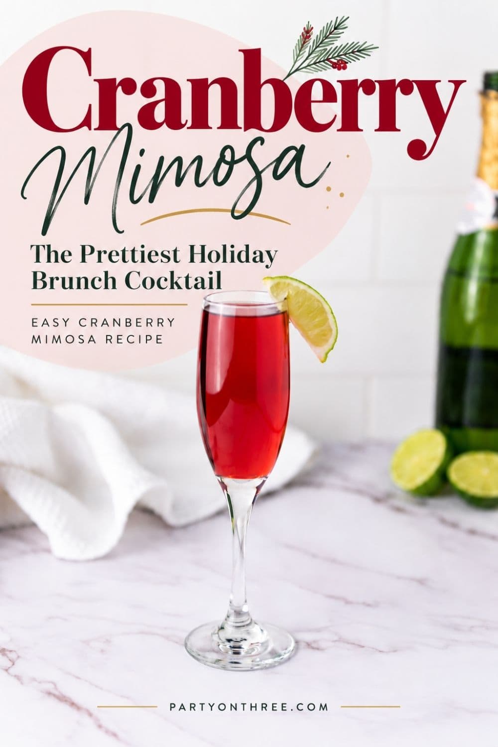 Cranberry Mimosa in a champagne flute with a lime wedge garnish, next to sparkling wine and fresh limes