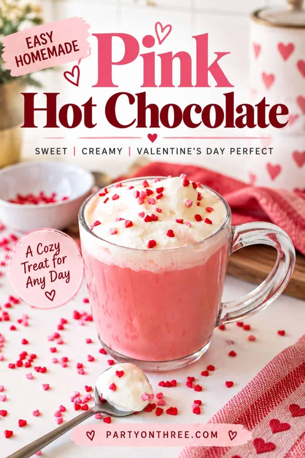 Easy homemade pink hot chocolate with whipped cream and heart sprinkles on a table with a heart dish towel