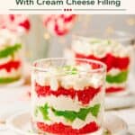 Mini Christmas Trifle Cups with layered red and green cake, cream cheese filling, and whipped topping