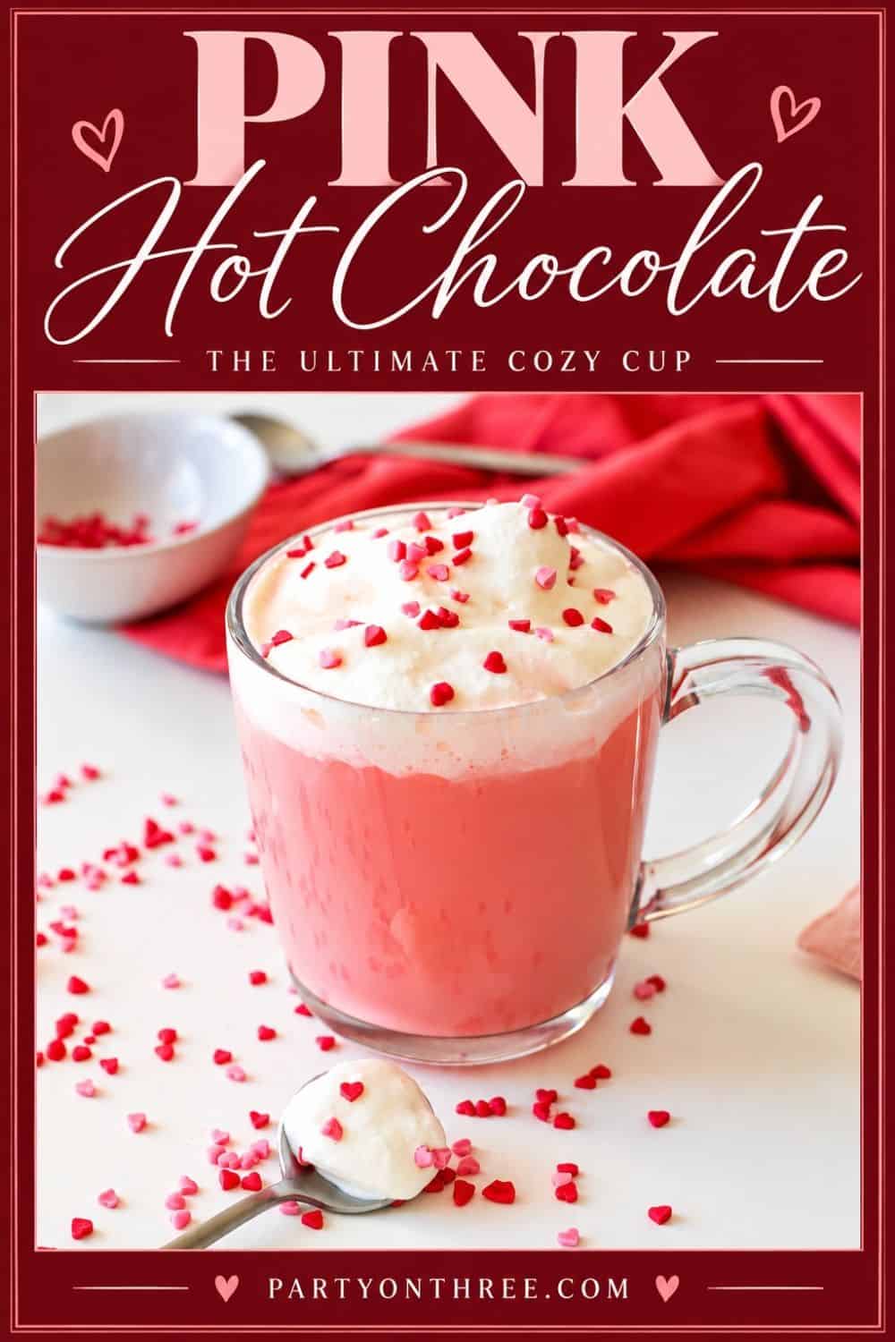 Pink hot chocolate made with a homemade red velvet recipe, topped with whipped cream and hearts