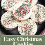 Ritz Cracker Christmas cookies coated in white chocolate and topped with red, green, and white sprinkles on a black plate